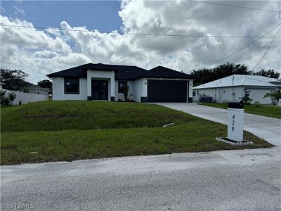 View of front facade with a front lawn and a garage | Image 1