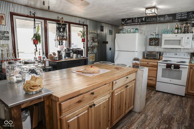 kitchen with wood counters, white appliances, dark wood finished floors, and a toaster | Image 23