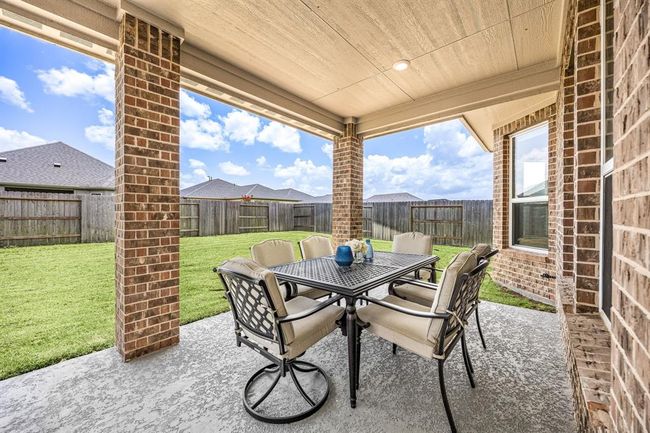 Dine outside overlooking the serene green space at the back of the home. | Image 29