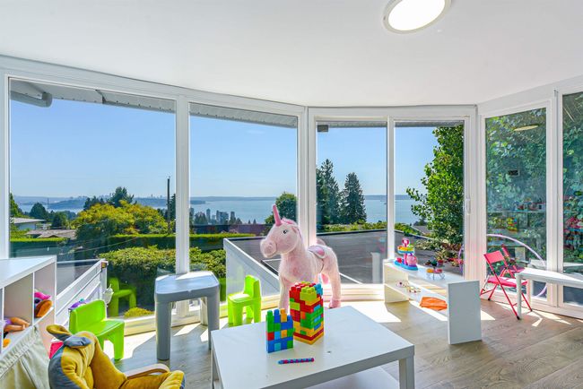Sunroom featuring healthy amount of natural light, wood finished floors, and a water view | Image 11