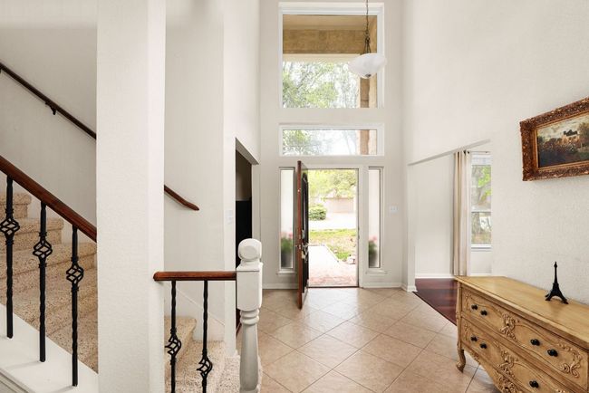 Foyer entrance featuring stairs, a high ceiling, baseboards, and light tile patterned flooring | Image 4