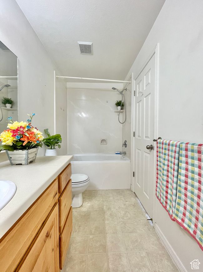 Full bathroom featuring vanity, shower / tub combination, tile patterned flooring, and toilet | Image 16