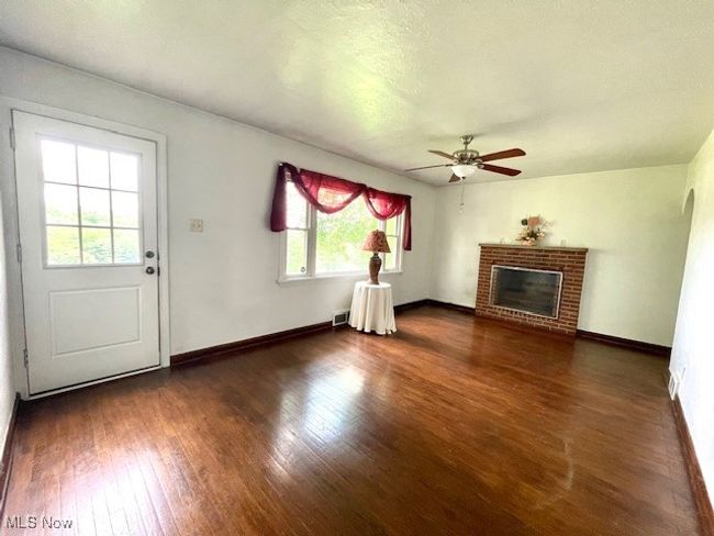 Living room featuring a ceiling fan, wood finished floors, front door onto a porch deck. | Image 9