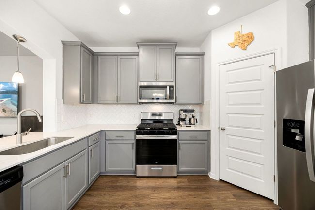 Kitchen featuring gray cabinets, appliances with stainless steel finishes, backsplash, light countertops, and recessed lighting | Image 15