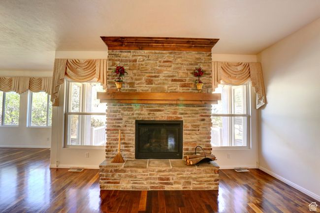 Unfurnished living room featuring a healthy amount of sunlight, wood finished floors, and baseboards | Image 8