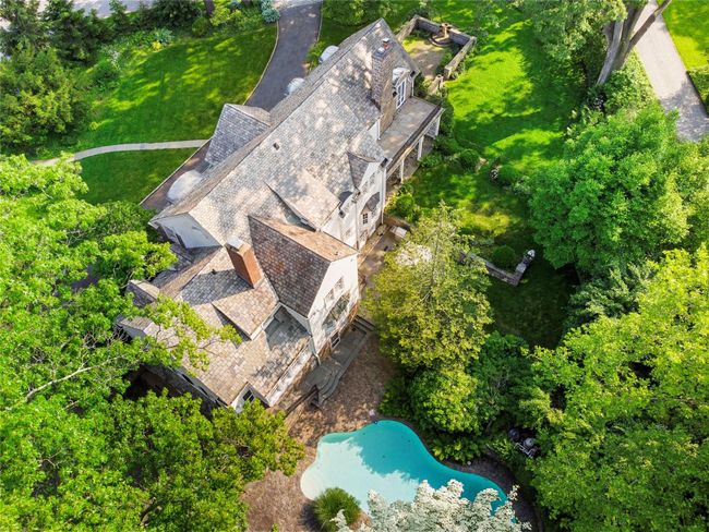 Aerial view of property and surrounding area with a pool and a tree filled landscape | Image 42