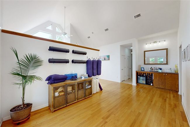 Living area featuring light wood finished floors, vaulted ceiling, visible vents, and ceiling fan | Image 8