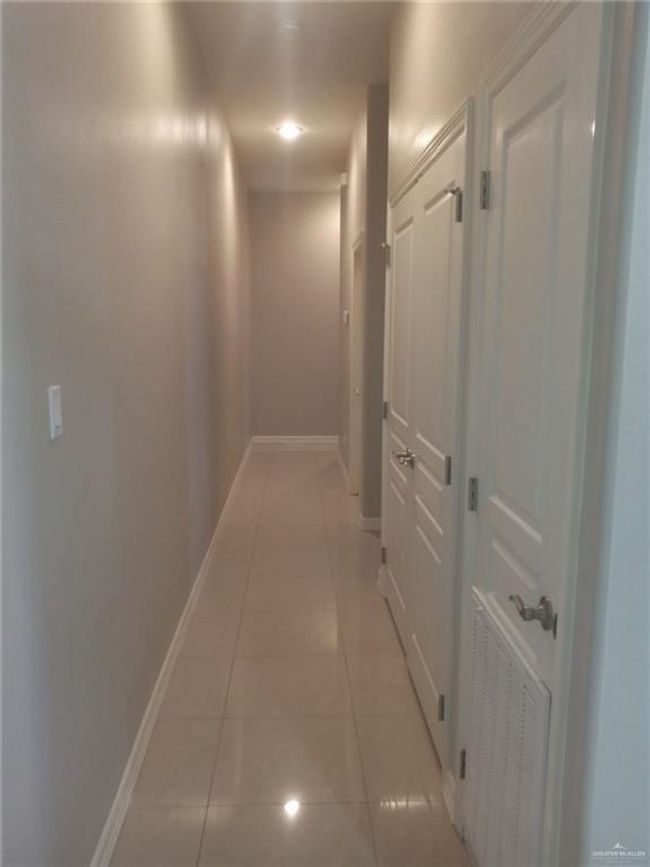 Hall with light tile patterned floors and baseboards | Image 6