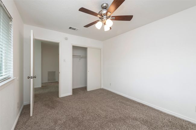 Unfurnished bedroom with ceiling fan, carpet, a closet, visible vents, and baseboards | Image 18