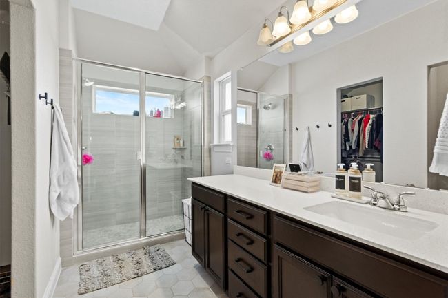 Full bathroom with plenty of natural light, vanity, a walk in closet, a stall shower, and vaulted ceiling | Image 20