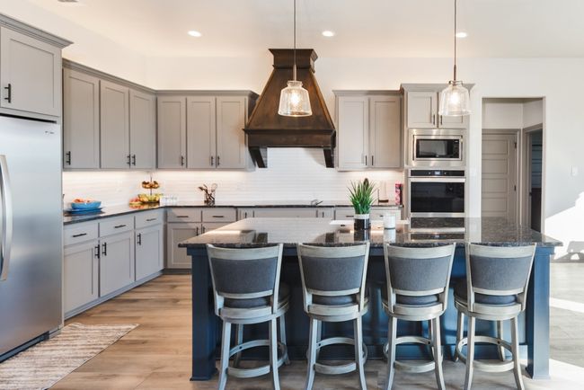 Kitchen with built in appliances, gray cabinets, decorative backsplash, and a breakfast bar area | Image 5