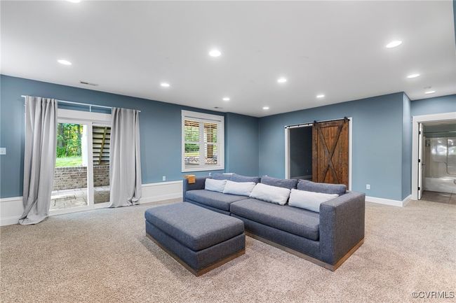 Carpeted living area featuring a barn door and recessed lighting | Image 38