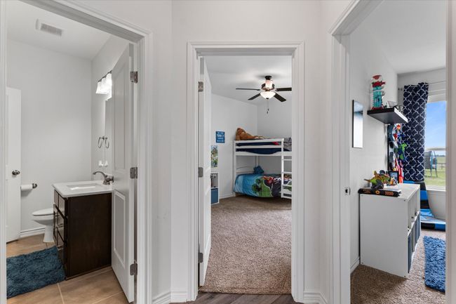 Corridor featuring visible vents, a sink, and light colored carpet | Image 26