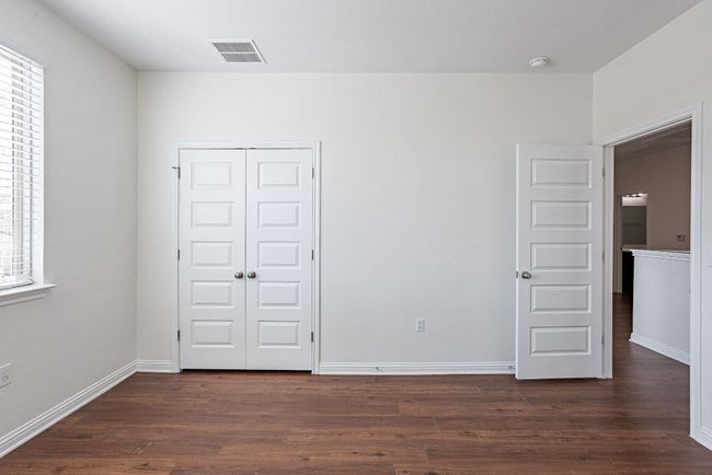 Unfurnished bedroom featuring a closet, dark wood-style floors, baseboards, and visible vents | Image 21