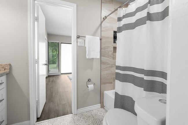 Full bathroom with toilet, vanity, and shower / bath combination with curtain | Image 17