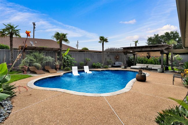 View of swimming pool with outdoor lounge area, a patio area, and a fenced backyard | Image 32