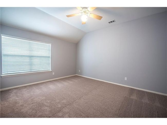 Unfurnished room featuring carpet floors, a ceiling fan, baseboards, and vaulted ceiling | Image 20