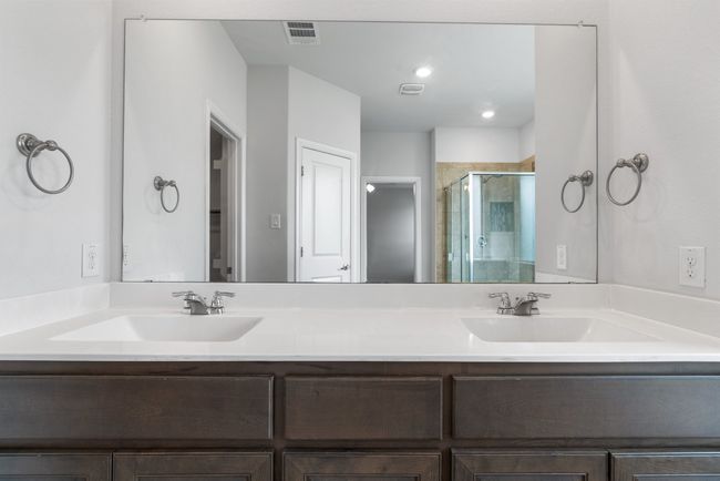 Bathroom with visible vents, a sink, a stall shower, and double vanity | Image 12