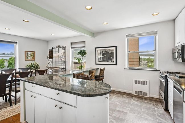 Kitchen with stainless steel appliances, radiator heating unit, recessed lighting, baseboards, and white cabinets | Image 4