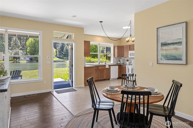 Bright dining and kitchen area with water views. | Image 9