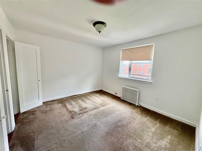 Carpeted empty room with radiator and baseboards | Image 5