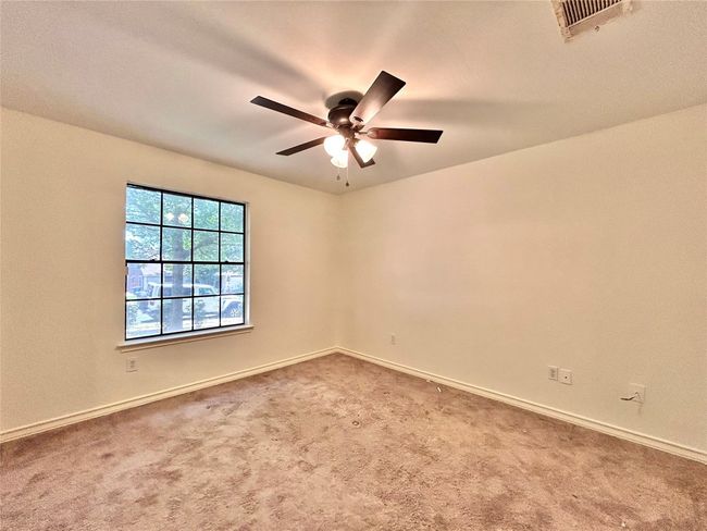 Carpeted empty room with ceiling fan and baseboards | Image 10