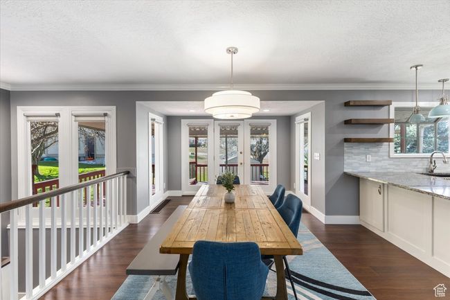 Dining space featuring a textured ceiling, french doors, dark wood-style flooring, and baseboards | Image 8