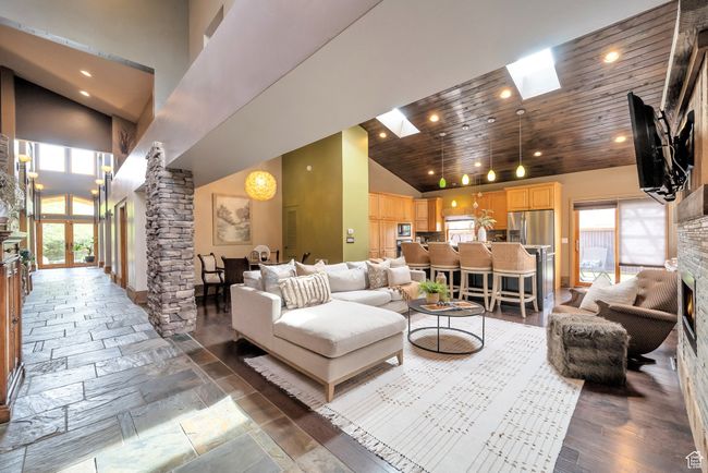 Living area featuring high vaulted ceiling, a skylight, decorative columns, and recessed lighting | Image 5