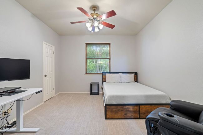 Bedroom with light colored carpet, baseboards, and a ceiling fan | Image 29