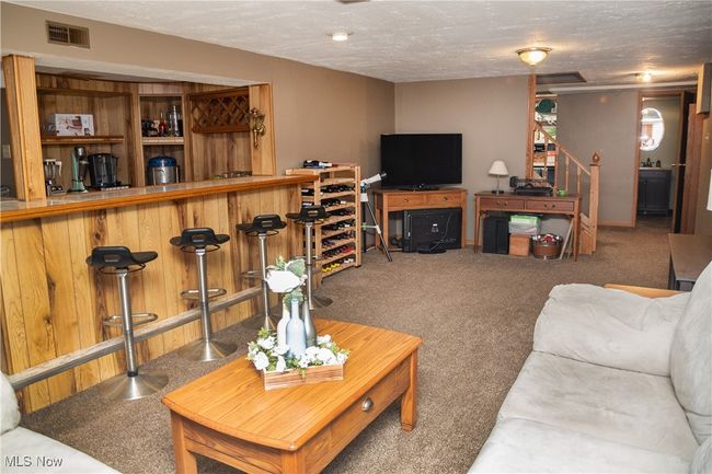 Rec area featuring carpet flooring, bar area, and a textured ceiling | Image 42