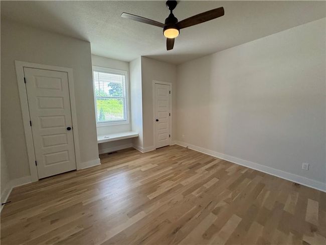 Unfurnished bedroom with light wood-style floors and a ceiling fan | Image 49
