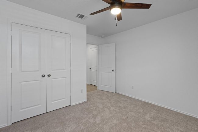 Unfurnished bedroom with carpet floors, a closet, and a ceiling fan | Image 23