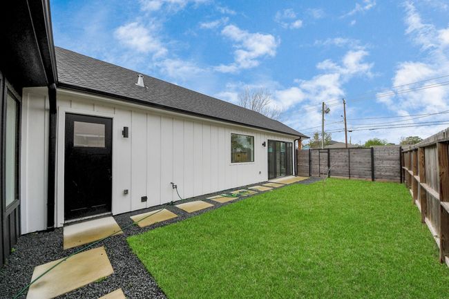 The yard has paving stones and plenty of green space. | Image 30
