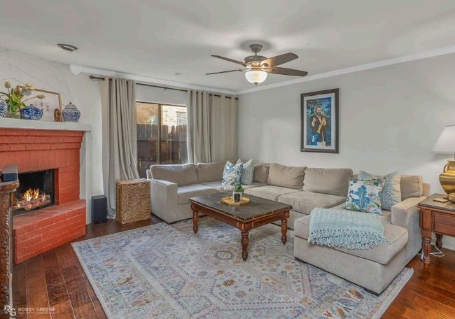 Living area with a ceiling fan, a brick fireplace, ornamental molding, and wood-type flooring | Image 5