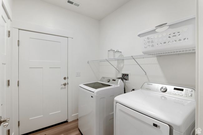 Laundry area with washing machine and clothes dryer and light wood finished floors | Image 7