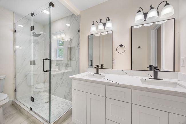 Bathroom featuring double vanity and a marble finish shower | Image 37
