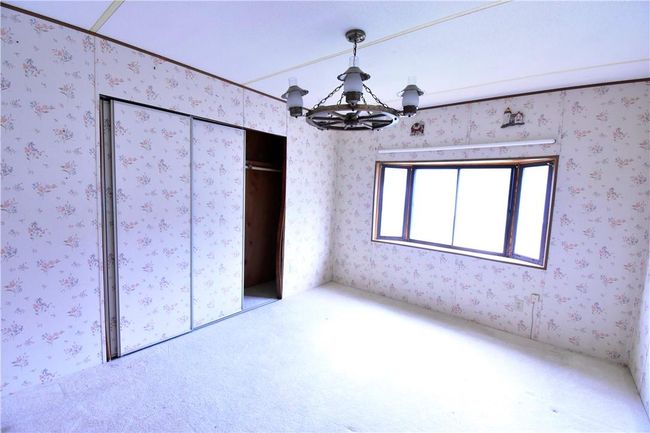 Unfurnished bedroom featuring an inviting chandelier and a closet | Image 29