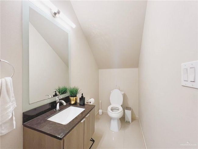 Bathroom with vanity, toilet, tile patterned floors, and lofted ceiling | Image 4