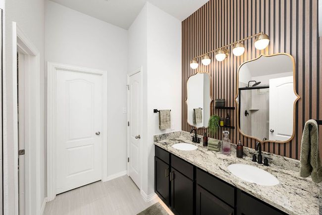 Full bathroom featuring double vanity, wall treatment, and custom closet with LVP flooring | Image 12