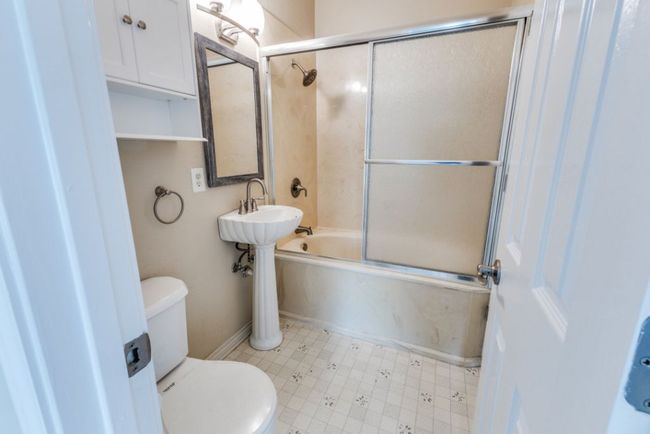 Bathroom featuring baseboards, shower / bath combination with glass door, and toilet | Image 32
