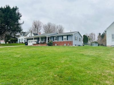 View of front of home featuring a front lawn and a garage | Image 1