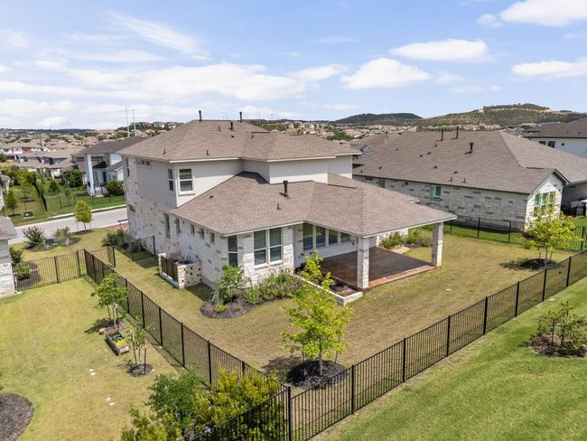 Rear view of property with a residential view, a shingled roof, a patio area, and stone siding | Image 37
