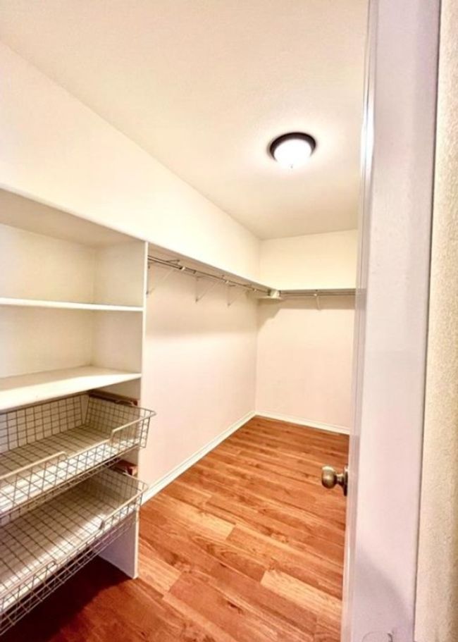 Walk in closet with wood finished floors | Image 10