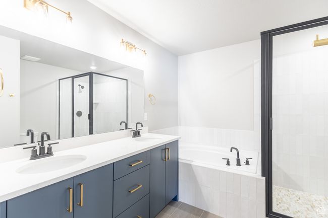 Bathroom featuring a stall shower, a bath, double vanity, and tile patterned flooring | Image 13