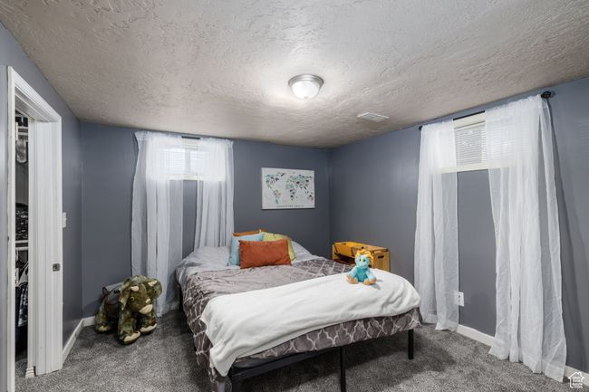 Carpeted bedroom with a textured ceiling and baseboards | Image 20
