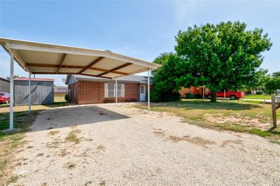 View of front of property with a 2 car carport and shed with electric hookups. | Image 1