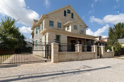 1509 Summer St is a two-story home featuring a covered front porch with wooden columns, surrounded by a wrought iron fence with gated entry, offering both privacy and curb appeal. | Image 1