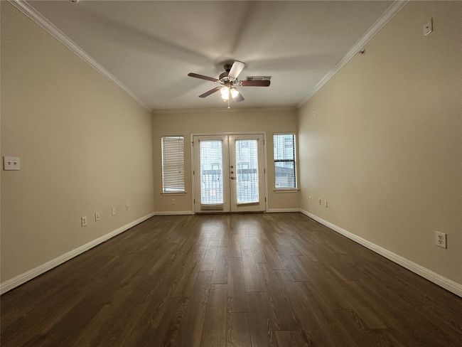 Unfurnished room with baseboards, dark wood finished floors, crown molding, and french doors | Image 4