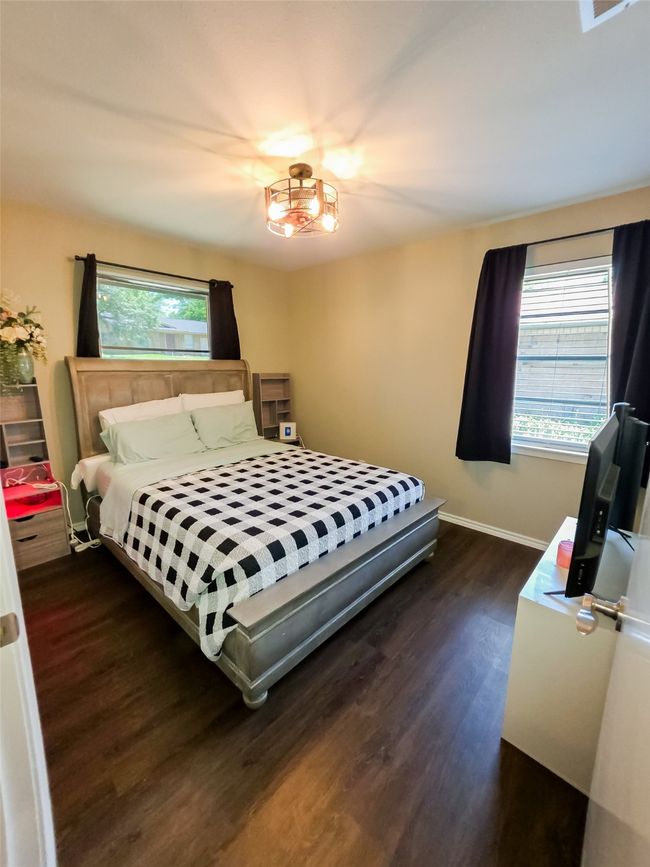 Bedroom featuring wood finished floors, multiple windows, and baseboards | Image 7