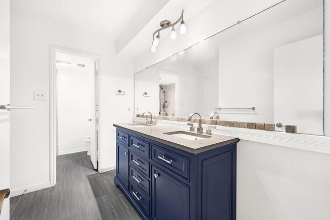 Secondary bathroom provides dual vanity sinks and a tub/shower combo. | Image 28